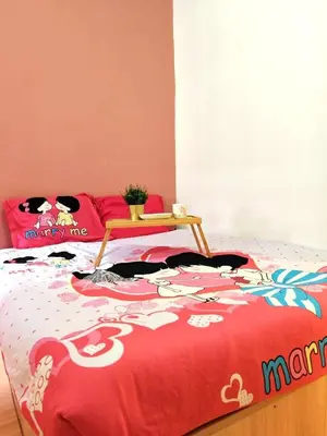 a bed with a red comforter with a table on it at GWarmStay@GoldenHillsNightMarket in Brinchang