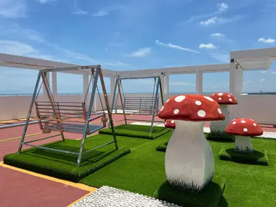 a balcony with two red mushrooms on the grass at Hot Picks SmartTV Netflix Seaview Homestay Sekinchan in Sekincan