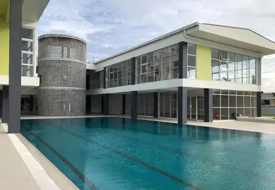 a building with a swimming pool in front of it at Balcony Forest Lake Mountain in Kampar