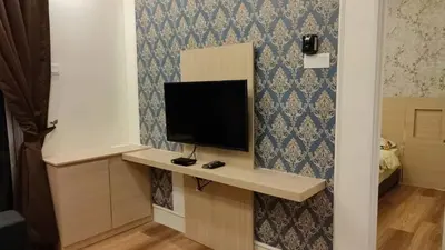 a room with a desk with a television on a wall at Adik Aisyah classic 2 in Cameron Highlands