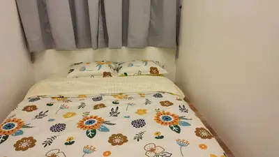 a bed with a bedspread with flowers on it at Adik Aisyah classic 2 in Cameron Highlands