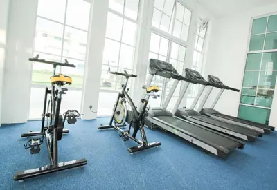 a gym with three exercise bikes in a room at The Trails of Kampar in Kampar