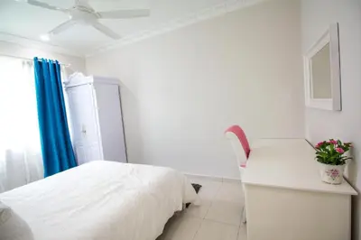 a bedroom with a bed and a desk and a chair at The Trails of Kampar in Kampar