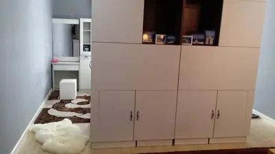 a kitchen with a large white cabinet with a rug at Champs Elysees in Kampar