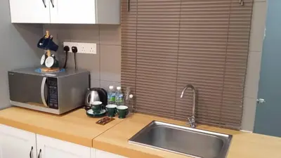 a kitchen counter with a sink and a microwave at Champs Elysees in Kampar