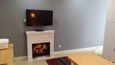 a living room with a fireplace with a flat screen tv over it at Champs Elysees in Kampar