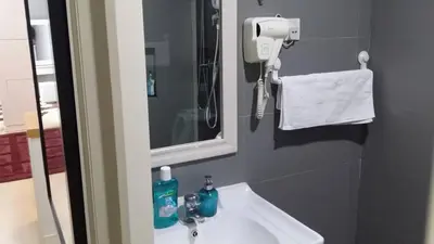 a bathroom with a sink and a phone on the wall at Champs Elysees in Kampar