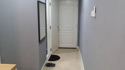 a hallway with a door and a mirror and a pair of shoes at Champs Elysees in Kampar