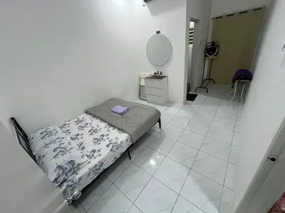 a small bed in a white room with a mirror at Zh homestay teluk batik in Lumut