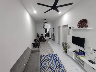 a living room with a ceiling fan and a tv at Zh homestay teluk batik in Lumut