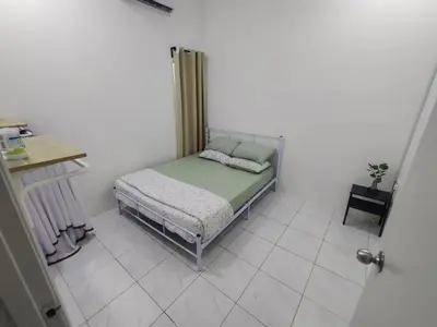 a small bedroom with a bed in a white room at Zh homestay teluk batik in Lumut