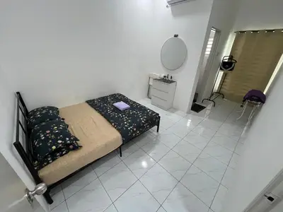 a bedroom with a bed and a mirror on a tiled floor at Zh homestay teluk batik in Lumut