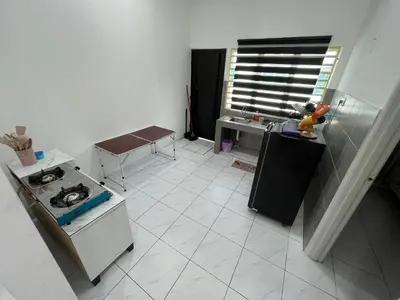 a small kitchen with a stove and a sink at Zh homestay teluk batik in Lumut