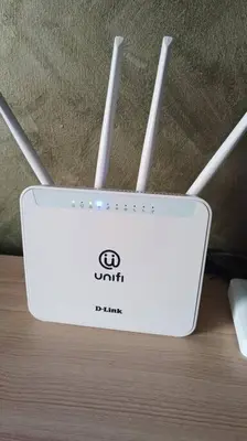 a white router sitting on a wooden table at Honeyz Waterpark Homestay. in Ipoh