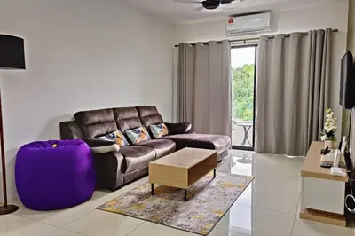 a living room with a leather couch and a table at Honeyz Waterpark Homestay. in Ipoh