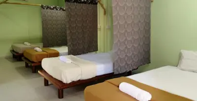 a room with three beds and a mirror at Pangkor Guesthouse SPK in Pangkor