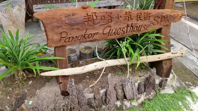 a wooden bench sitting on top of a tree stump at Pangkor Guesthouse SPK in Pangkor