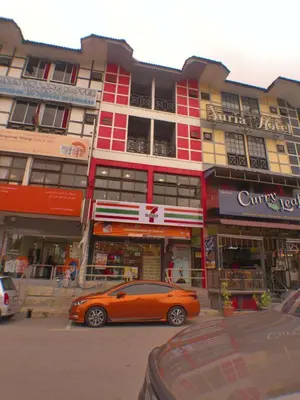 an orange car parked in front of a building at BRICKS Cameron Hostel in Tanah Rata