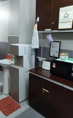 a kitchen with a counter with a microwave and a sink at BRICKS Backpackers Sleepbox in Tanah Rata