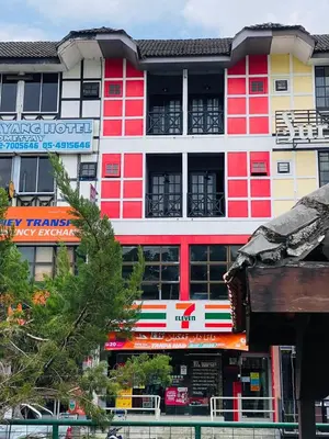 a red and white building with trees in front of it at BRICKS Backpackers Sleepbox in Tanah Rata