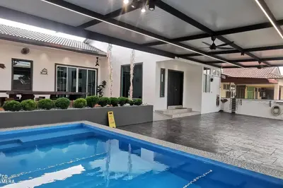 a swimming pool in front of a house at Kulim Mini HomeStay in Kulim