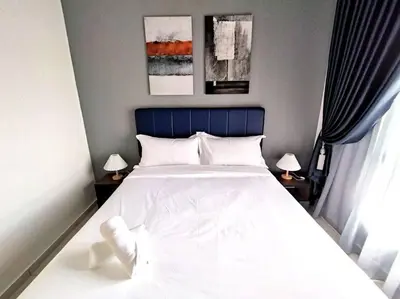 a bedroom with a large white bed with two lamps at Urbanite Premier Suite - Horizon Ipoh by Grab A Stay in Ipoh