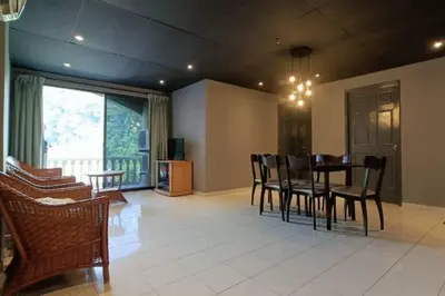 a living room with a dining room table and chairs at Coral Bay \u5c0f\u578b\u516c\u5bd3 in Pasir Bogak