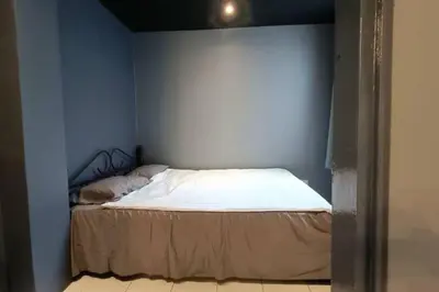 a bed in a room with a blue wall at Coral Bay \u5c0f\u578b\u516c\u5bd3 in Pasir Bogak