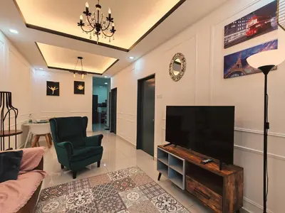 a living room with a flat screen tv and a chair at WHITE ON HOMESTAY CAMERON BY ICOLOR in Tanah Rata