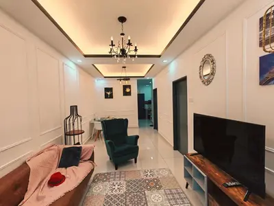 a living room with a tv and a couch and a table at WHITE ON HOMESTAY CAMERON BY ICOLOR in Tanah Rata