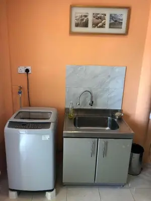 a kitchen with a sink and a stove at Supreme Homestay in George Town