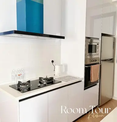 a white kitchen with a stove and a refrigerator at The Beacon Executive Penang Georgetown in George Town