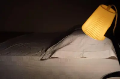 a close up of a bed with a lamp on it at Taiping Modern Home in Kamunting