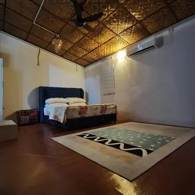 a bedroom with a bed and a rug on the floor at Kampung Cottage Bagan Datuk in Selekoh