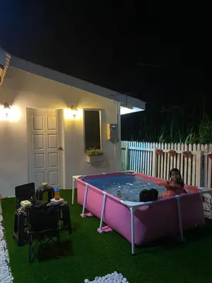 a person in a hot tub in a backyard at night at Kampung Cottage Bagan Datuk in Selekoh