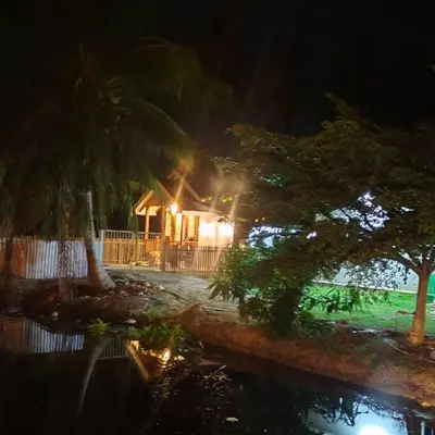 a house at night with a pond in front of it at Kampung Cottage Bagan Datuk in Selekoh