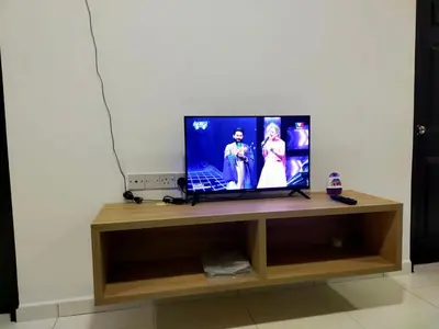 a television sitting on a wooden stand in a room at Homestay Manitha in Seri Manjung