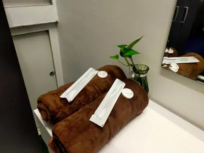two brown towels sitting on a counter in front of a mirror at Homestay Manitha in Seri Manjung