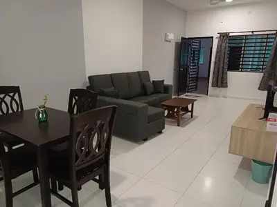 a living room with a couch and a table and chairs at Homestay Manitha in Seri Manjung