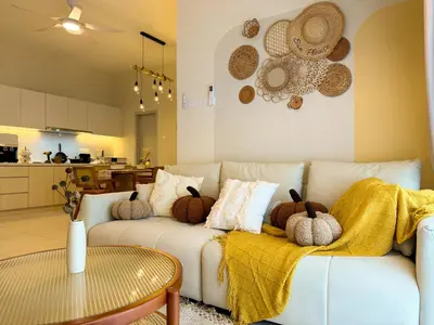 a living room with a white couch with pillows at The Horizon Ipoh By Iconique Espace in Ipoh
