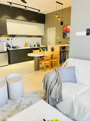a living room with a couch and a kitchen at The Horizon Ipoh By Iconique Espace in Ipoh