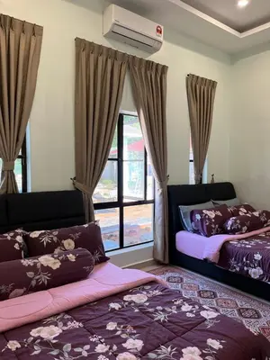a bedroom with two beds and a window at Tambun Hillview Cottage 2 in Ipoh