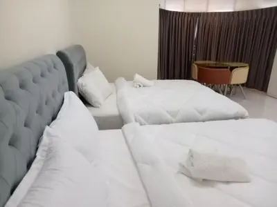 a bedroom with two beds with white pillows at BUTTERWORTH RAJA UDA RAYA HOMESTAY in Butterworth