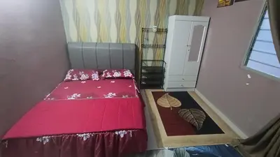 a small bedroom with a red bed and a window at Homestay Rezeki Batu Gajah in Batu Gajah