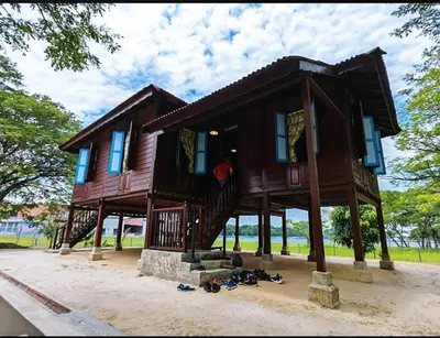 a large wooden house with blue windows at Homestay Rezeki Batu Gajah in Batu Gajah