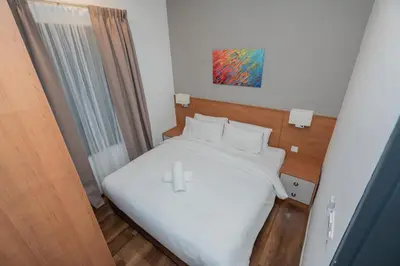 a small bedroom with a bed with white sheets at Ipoh Tambun Lost World Sunway Onsen Mina 3R2B 8pax in Tambun