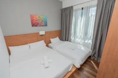 two beds in a room with a window at Ipoh Tambun Lost World Sunway Onsen Mina 3R2B 8pax in Tambun