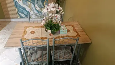 a table with two chairs and a vase of flowers on it at HOMESTAY Rezeki in Batu Gajah