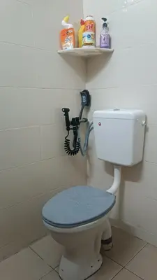 a bathroom with a toilet with a blue lid at HOMESTAY Rezeki in Batu Gajah