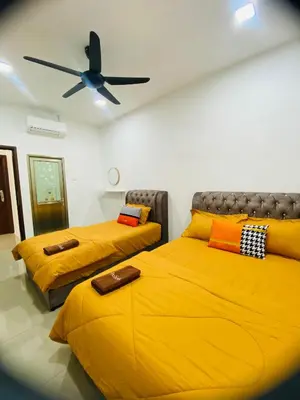 a bedroom with two beds and a ceiling fan at LH SUITE HOMESTAY Gua Musang- Masjid Mekah in Gua Musang